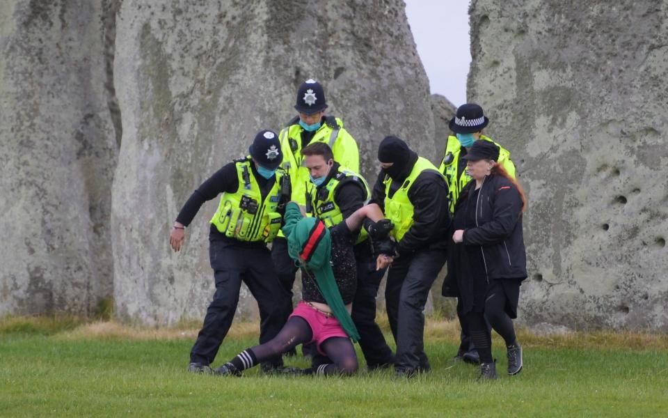 People are removed by police officers after crowds gathered at Stonehenge on June 21 2021 - Finnbarr Webster/Getty Images