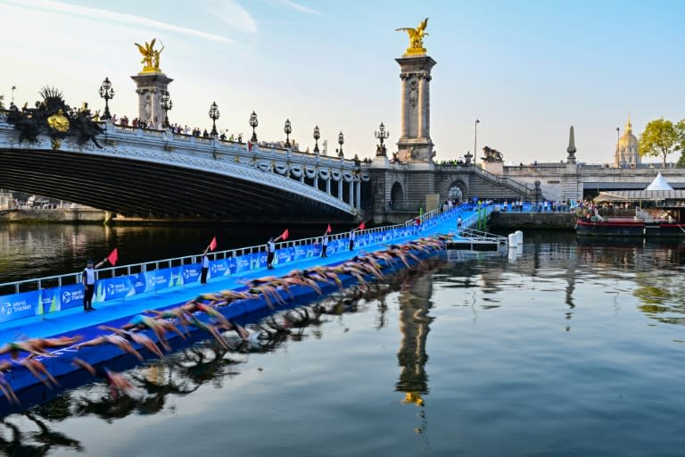 Des athlètes plongent dans la Seine, au niveau du pont Alexandre III, à Paris, lors d'une épreuve test du triathlon femmes pour les Jeux Olympiques 2024, le 17 août 2023 (Miguel MEDINA)