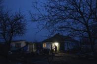 Maryna Semeniuk walks in the yard in front of her house in Vysoke village, Kherson region, Ukraine, Saturday, Dec. 3, 2022. Semeniuk's husband Mykola was injured by Russian soldiers in November and forcibly moved to Crimea, as well two of her sons were captured by Russian forces in July. (AP Photo/Evgeniy Maloletka)