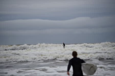 A surfer is seen on rough water in the Atlantic on the eve of storm Ophelia in an area where the tide should be out in the County Clare town of Lahinch, Ireland October 15, 2017. REUTERS/Clodagh Kilcoyne