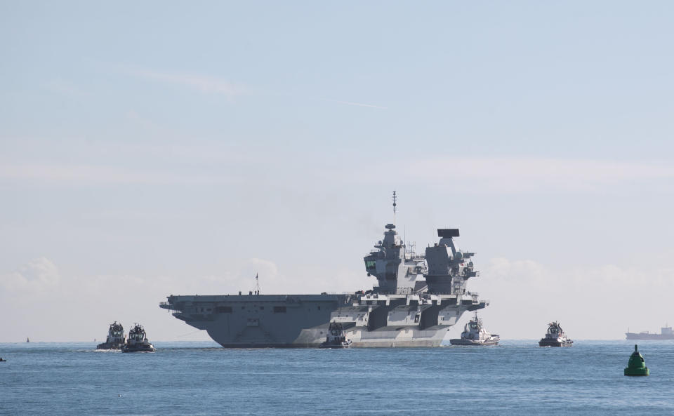 People watch as the 65,000-tonne HMS Queen Elizabeth, the UK's newest aircraft carrier, departs from Portsmouth Naval Base, the carrier is due to spend a month at sea around the south-west of the United Kingdom testing out its radar, communications and other technical equipment.