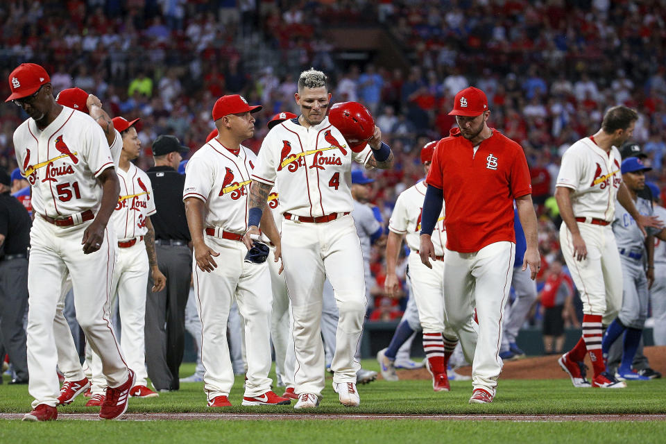 St. Louis Cardinals' Yadier Molina, center, walks toward first base as the rest of his teammates walk back to the dugout after a bench-clearing argument after he was hit by pitch during the second inning of a baseball game against the Chicago Cubs, Saturday, Sept. 28, 2019, in St. Louis. (AP Photo/Scott Kane)