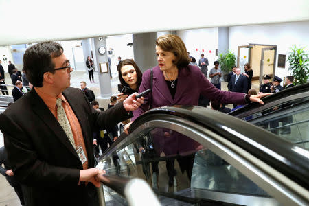 Reporters trail U.S. Senator Dianne Feinstein (D-CA) as she arrives ahead of a vote on a bill to renew the National Security Agency's warrantless internet surveillance program, at the U.S. Capitol in Washington, U.S. January 18, 2018. REUTERS/Jonathan Ernst