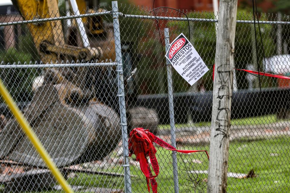 A sign in the alleyway alerts the community the demolition of the building at 3143 Cass avenue has asbestos in midtown Detroit on Saturday, July 29, 2023. 