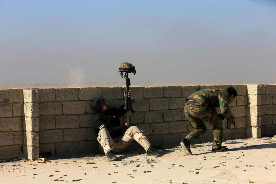 An Iraqi soldier uses his helmet to distract the opposing sniper