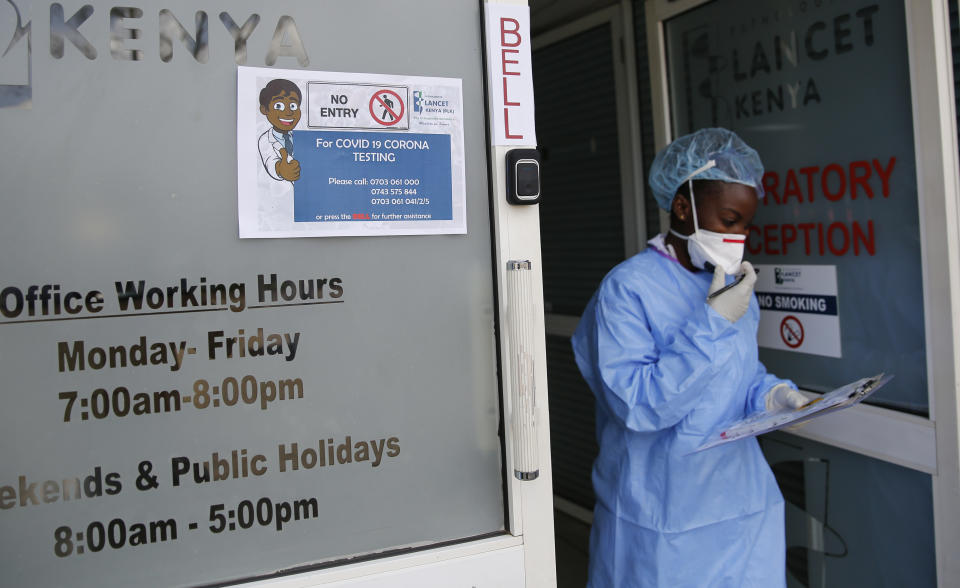 In this photo taken Sunday, April 5, 2020, laboratory technician Irene Ooko walks outside to take a nasal sample from a patient seeking a test for the new coronavirus that causes COVID-19, at the Pathologists Lancet Kenya laboratory in Nairobi, Kenya. The company, which is offering tests to patients with a doctor's referral, was previously having to send samples to South Africa for testing but is now completing the testing in-house in Kenya. (AP Photo/Brian Inganga)