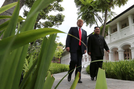 U.S. President Donald Trump and North Korea's leader Kim Jong Un walk together before their working lunch during their summit at the Capella Hotel on the resort island of Sentosa, Singapore June 12, 2018. Picture taken June 12, 2018. REUTERS/Jonathan Ernst