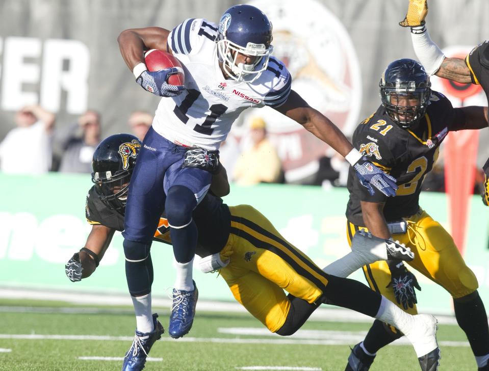 Argonauts' Inman evades a tackle by Tiger-Cats' Bussey in the first half of their CFL football game in Guelph