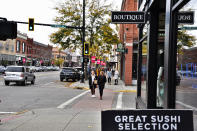 People explore Main Street in Bozeman, Mont., on Thursday, Oct. 14, 2021. Bozeman has become a hotbed for startups and pandemic-era remote workers. Home to Montana State University, Bozeman grew a whopping 33% in the last decade, growth that dwarfs anywhere else in the state. (AP Photo/Iris Samuels)