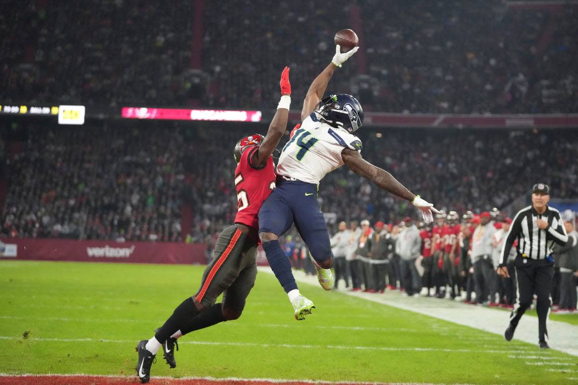 Seattle Seahawks’ DK Metcalf (14) is defended by Tampa Bay Buccaneers’ Jamel Dean (35) during the second half of an NFL football game, Sunday, Nov. 13, 2022, in Munich, Germany. The pass was incomplete. (AP Photo/Matthias Schrader)