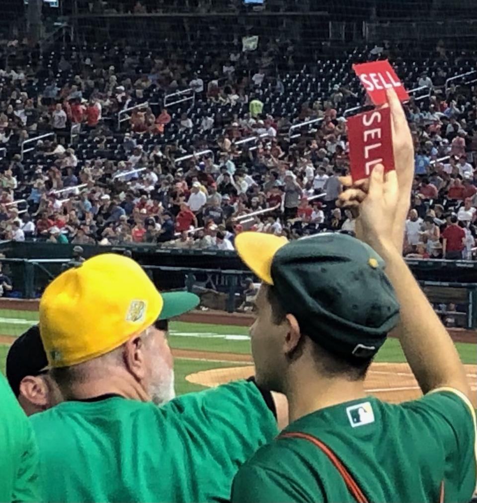 Oakland A’s fans hold up cards instructing how and when to chant in support of their club Friday at Nationals Park in Washington.