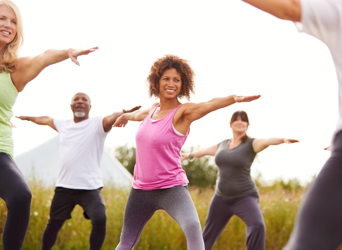 fitness group doing yoga outdoors