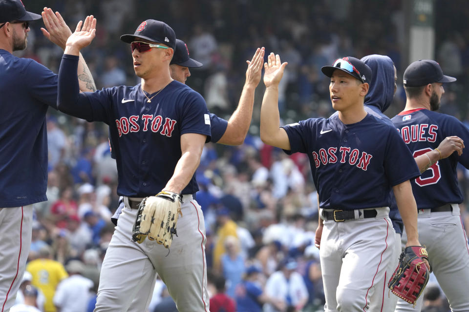 Boston Red Sox's Rob Refsnyder, left, and Masataka Yoshida, of Japan, celebrate with teammates after the Red Sox defeated the Chicago Cubs 11-5 in a baseball game in Chicago, Sunday, July 16, 2023. (AP Photo/Nam Y. Huh)