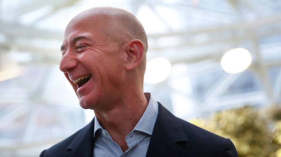 Amazon founder and CEO Jeff Bezos laughs as he talks to the media while touring the new Amazon Spheres during the grand opening at Amazon's Seattle headquarters in Seattle, Washington, U.S., January 29, 2018. REUTERS/Lindsey Wasson - RC1DD03FA240