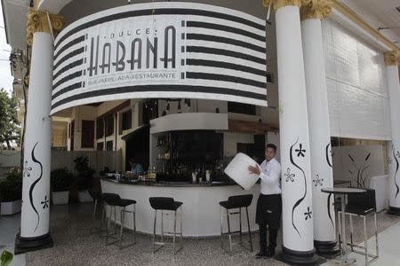 An employee works at a privately-run restaurant in Havana January 16, 2015. Despite more than five decades of hostility between Washington and Havana, and Cuba's Cold War alliance with the Soviet bloc of communist countries, many Cubans admire U.S. culture even if they oppose its politics and the long trade embargo against their country. Following U.S. President Barack Obama's historic shift in Cuba policy last month, the two governments meet on Wednesday and Thursday to set about restoring diplomatic relations. Picture taken January 16, 2015. To match CUBA-USA/MOOD REUTERS/Stringer (CUBA - Tags: POLITICS SOCIETY)