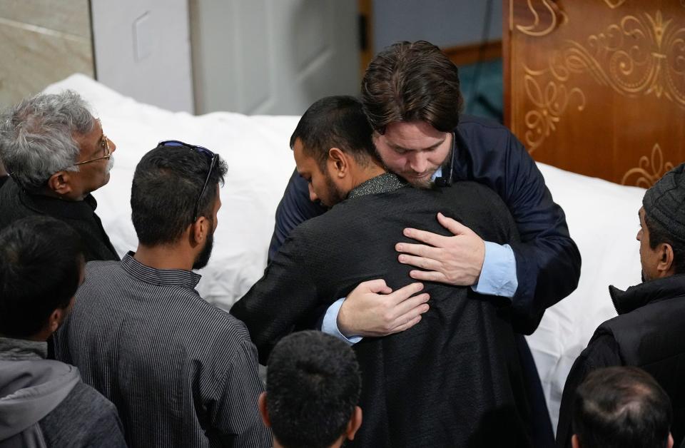 Sheikh Joe Bradford, right, consoles Ishraq Islam at the funeral for Islam's wife, Sabrina Rahman. Islam and Rahman married in 2020 and moved to Austin last year.