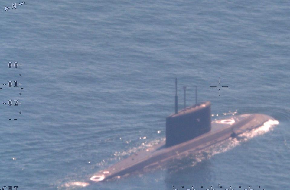 A hazy image of a Russian submarine surfacing from the sea.