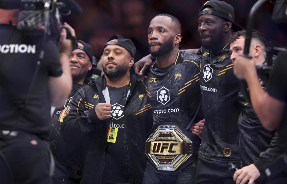 UFC welterweight champion Leon Edwards, center, poses with his team and championship belt after defeating Colby Covington during the UFC 296 mixed martial arts event Saturday, Dec. 16, 2023, in Las Vegas. Edwards retained his title by unanimous decision. (Steve Marcus/Las Vegas Sun via AP)