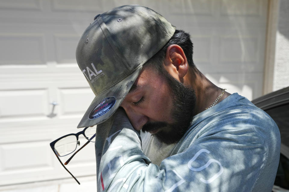 FILE - After finishing up an air conditioning repair call, Michael Villa, a service tech with Total Refrigeration, finds shade as he wipes sweat from his face July 19, 2023, in Laveen, Ariz. (AP Photo/Ross D. Franklin, File)