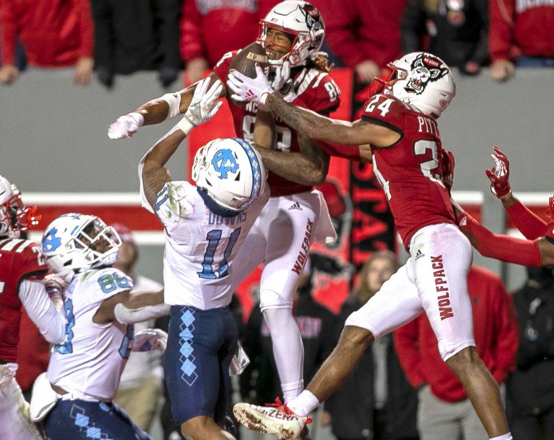 N.C. State’s Derrick Pitts (24), right, intercepts a pass intended for North Carolina’s Josh Downs (11) on the final play of the game to secure the Wolfpack’s 34-30 victory over the Tar Heels during their 2021 game at Carter-Finley Stadium.