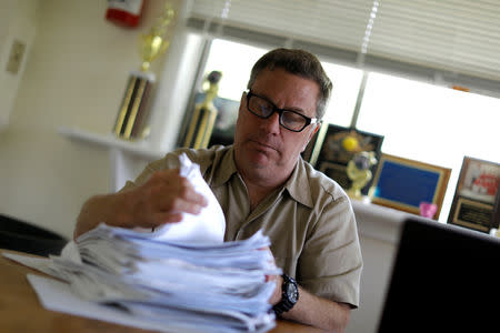 FILE PHOTO: Scott Rosmarin, owner and operator of Rosmarins Day Camp and Cottages, sorts campers' immunization forms at the camp office in Monroe, New York, U.S., May 20, 2019. Picture taken May 20, 2019. REUTERS/Mike Segar