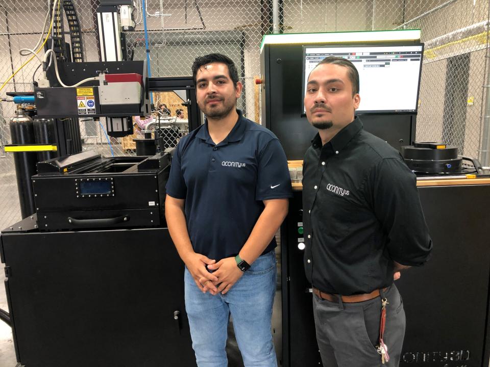 Jose Gonzalez, right, director of operations, and Tomas Mijares, field engineer, for German company Aconity3D's U.S. operations based inside the El Paso Airport's new Innovation Factory. The UTEP graduates came back to El Paso to work for the company. They stand by one of its 3D printing systems inside the facility July 19.