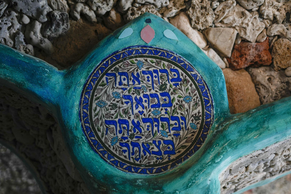 A "welcome home" blessing made of stone sits at Nissim Kahlon's home chiseled out of the sandstone cliffs overlooking the Mediterranean sea in Herzliya, Israel, Wednesday, June 28, 2023. Over half a century, Kahlon has transformed a tiny cave on a Mediterranean beach into an elaborate underground labyrinth filled with chiseled tunnels, detailed mosaic floors and a network of staircases and mysterious chambers. Fifty years after Kahlon moved into the home, Israel's Environmental Protection Agency has served him an eviction notice, claiming the structure threatens Israel's coastline. (AP Photo/Ariel Schalit)