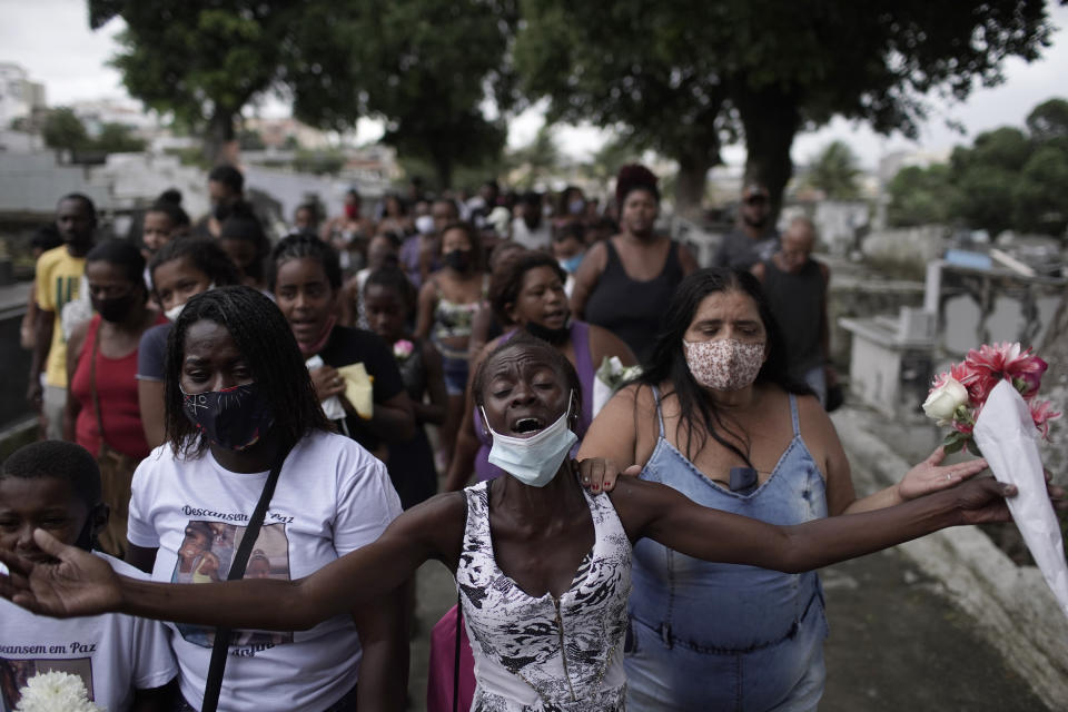 Relatives of Emily Victoria Silva dos Santos, 4, and Rebeca Beatriz Rodrigues dos Santos, 7, mourn during their burial at a cemetery in Duque de Caxias, Rio de Janeiro state, Brazil, Saturday, Dec. 5, 2020. Grieving families held funerals for Emily and Rebeca, killed by bullets while playing outside their homes. Weeping and cries of “justice” were heard Saturday at their funerals, reflecting the families’ assertion that the children were killed by police bullets. (AP Photo/Silvia Izquierdo)