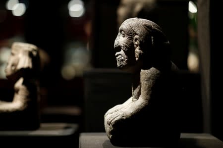 A stone kneeling figure of goddess of fertility and land Coatlicue, pone of pre-Columbian artefacts, is presented to the press at Drouot auction house in Paris