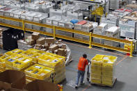 FILE - In this Aug. 3, 2017, file photo, a worker pushes bins at an Amazon fulfillment center in Baltimore. Amazon will spend more than $700 million to provide additional training to about one-third of its U.S. workforce. (AP Photo/Patrick Semansky, File)