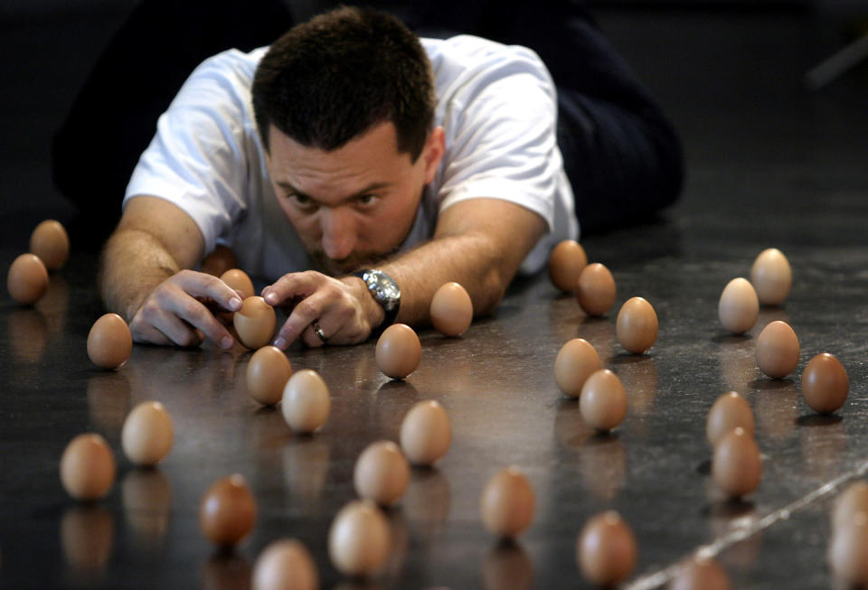 Brian Spotts of the U.S. works to balance 439 eggs on their ends on the floor of the Australian Centre for Contemporary Art in Melbourne September 14, 2005. Spotts, who lives in Colorado, travelled to Melbourne to attempt a new world egg balancing record which currently stands at 420 eggs. REUTERS/James Bodington/Handout