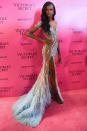 <p>In an embellished, sheer gown with a feather skirt.</p>