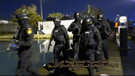 A still image taken from a video provided by Bahraini security officials shows Bahraini forces preparing to raid a speedboat manned by Shi’ite militant fugitives it says were heading for Iran from Bahrain’s northeastern coast, February 9, 2017. Text on screen reads, "Joint force of the operation formed up of police aircrafts, coast guards, rapid response force."Bahraini security officials/Handout via REUTERS