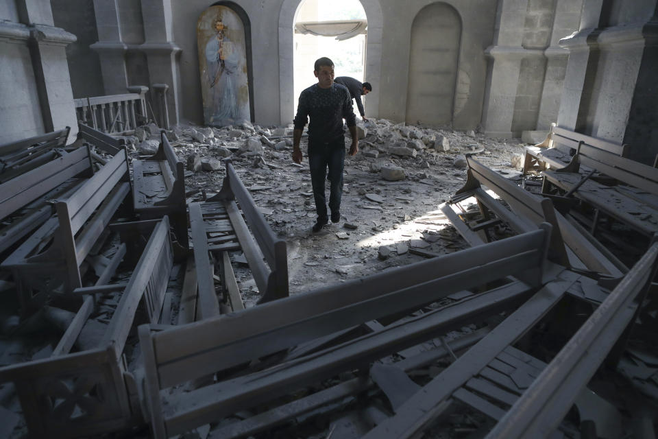 A man walks in rubbles of the Ghazanchetsots (Holy Saviour) Cathedral in the city of Shusha, some 15 kilometers from the Nagorno-Karabakh province's capital Stepanakert, Thursday, Oct. 8, 2020, after shelling by Azerbaijani artillery. Armenia accused Azerbaijan of firing missiles into the capital of the separatist territory of Nagorno-Karabakh, while Azerbaijan said several of its towns and its second-largest city were attacked. (Vahram Baghdasaryan/Photolure via AP)