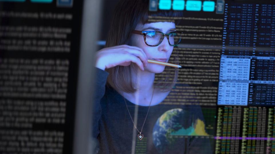 An IT professional checks a computer screen.