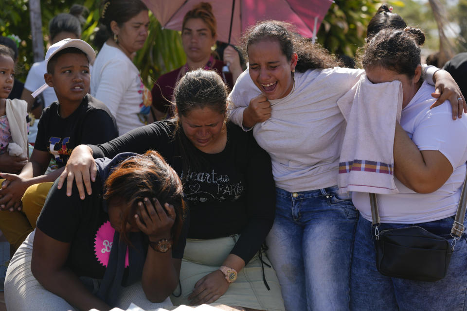 People cry during the burial of miner Santiago Mora at the cemetery in La Paragua, Bolivar state, Venezuela, Thursday, Feb. 22, 2024. The collapse of an illegally operated open-pit gold mine in central Venezuela killed at least 14 people and injured several more, state authorities said on Feb. 21, as some other officials reported an undetermined number of people could be trapped. (AP Photo/Ariana Cubillos)