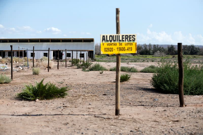 A sign reading "Rentals and Sales of Lots" is seen in front of an unfinished building, in Anelo