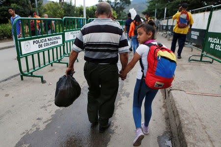 A man and a girl cross into Venezuela from Colombia via the Simon Bolivar international bridge in Cucuta, Colombia August 8, 2018. REUTERS/Luisa Gonzalez