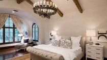 The bedrooms are decorated with ornate cabinetry and lavish bed linen, with massive, sprawling windows and exposed beams.