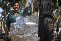 Dan Hirning, founding president of Firezat Inc., poses for a portrait as he holds some of the material that protects homes from fires, his company uses, Thursday, Sept. 16, 2021, in Del Mar, Calif. Aluminum wraps designed to protect homes from flames are getting attention as wildfires burn in California. During a fire near Lake Tahoe, some wrapped houses survived while nearby homes were destroyed. (AP Photo/Gregory Bull)