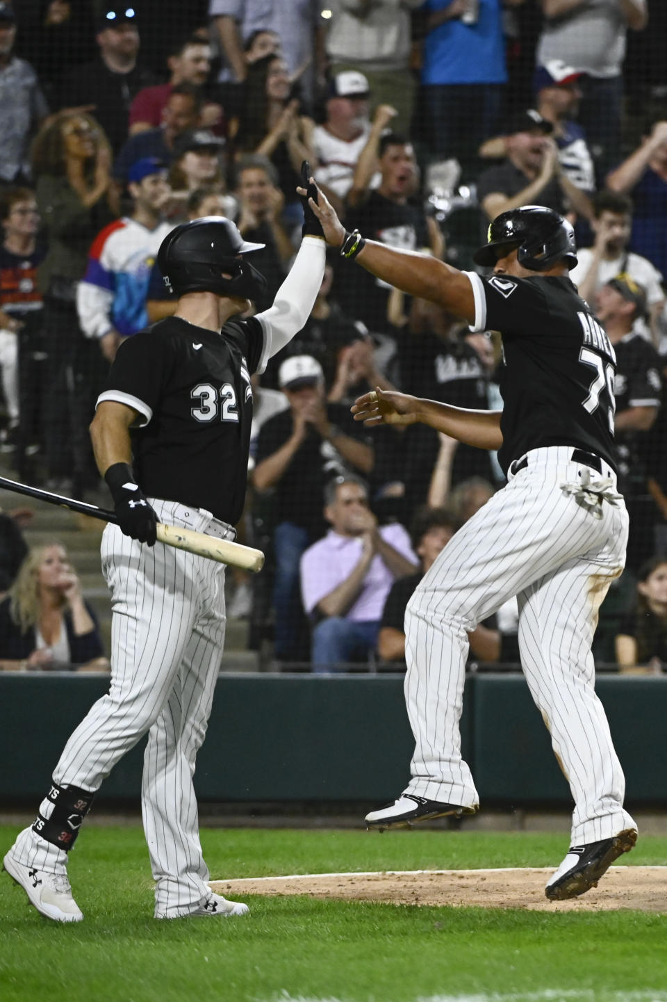 Chicago White Sox's Gavin Sheets (32) high-fives Jose Abreu (79), who scored against the Detroit Tigers during the seventh inning of a baseball game Saturday, Aug. 13, 2022, in Chicago. (AP Photo/Matt Marton)