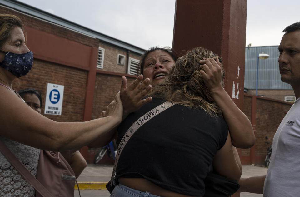 A woman is consoled after learning her brother died from consuming toxic cocaine, outside the Bocalandro Hospital near the Puerta 8 neighborhood, a suburb north of Buenos Aires, Argentina, Feb. 4, 2022. A batch of cocaine has killed at least 23 people and hospitalized many more in Argentina, according to police. (AP Photo/Rodrigo Abd)