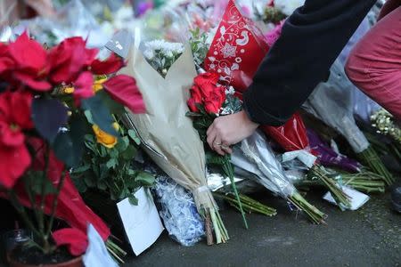 A fan lays flowers outside the house of singer George Michael, where he died on Christmas Day, in Goring, southern England, Britain December 26, 2016. REUTERS/Eddie Keogh