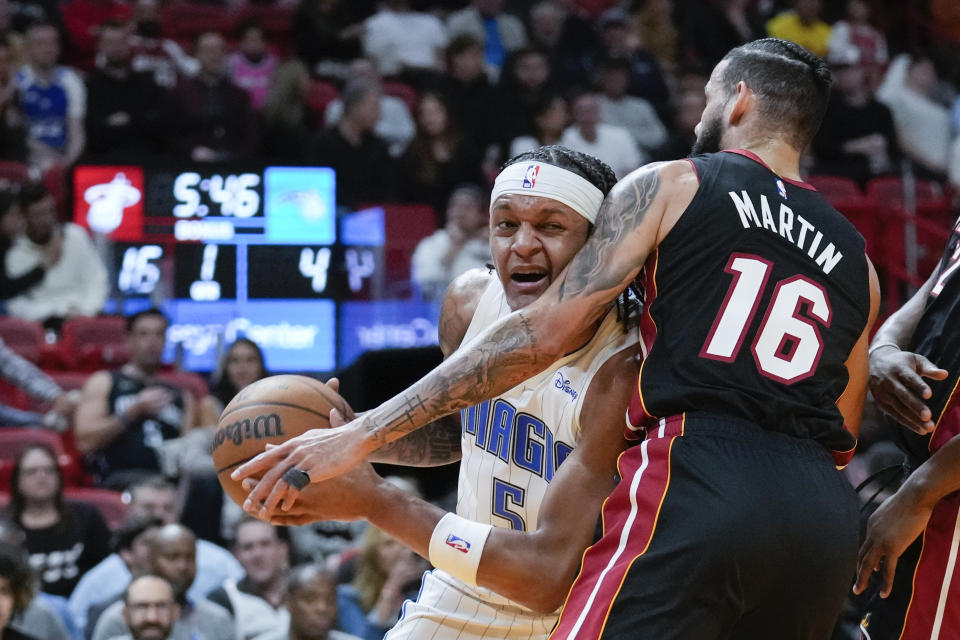 Orlando Magic forward Paolo Banchero (5) tries to drive past Miami Heat forward Caleb Martin (16) during the first half of an NBA basketball game Tuesday, Feb. 6, 2024, in Miami. (AP Photo/Rebecca Blackwell)