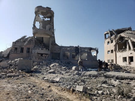 People inspect the site of Saudi-led air strikes on a Houthi detention centre in Dhamar