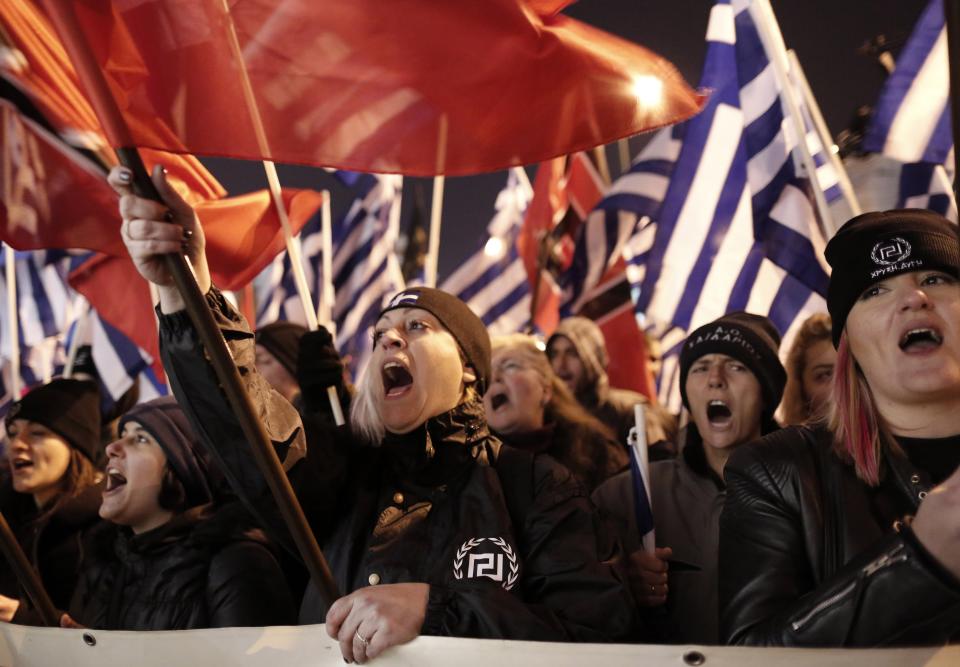 Supporters of Greece's extreme right party Golden Dawn shout slogans during a rally in Athens on Saturday, Feb.1, 2014. About 3,000 people took part in the rally to commemorate a 1996 incident which cost the lives of three navy officers and brought Greece and Turkey to the brink of war. A number of leftist groups held two separate counter-rallies a short distance away, but police forbade the groups from marching and meeting each other to prevent violent incidents. Six lawmakers of the party, including the Golden Dawn's leader Nikolaos Michaloliakos, are in jail on charges of being prominent members of a criminal organization. (AP Photo/Yannis Kolesidis)