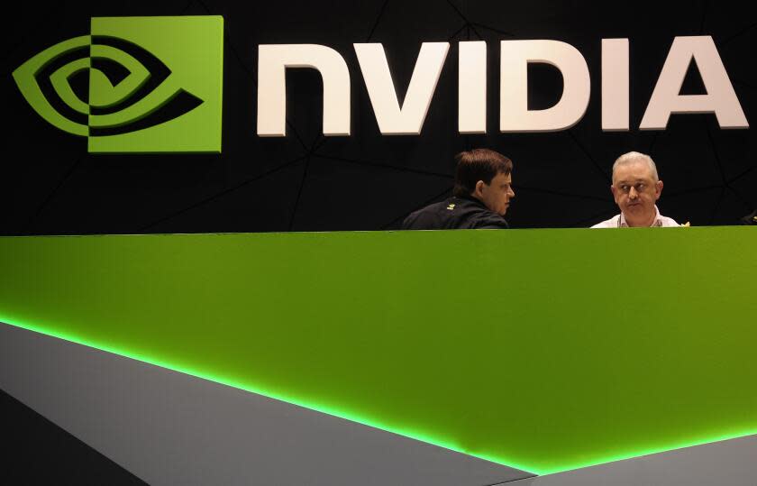 FILE - People gather in the Nvidia booth at the Mobile World Congress mobile phone trade show Thursday, Feb. 27, 2014 in Barcelona, Spain. The Federal Trade Commission on Thursday, Dec. 2, 2021 sued to block graphics chip maker Nvidia's $40 billion purchase of chip designer Arm, saying the deal would create a powerful company that could hurt the growth of new technologies. (AP Photo/Manu Fernandez, File)