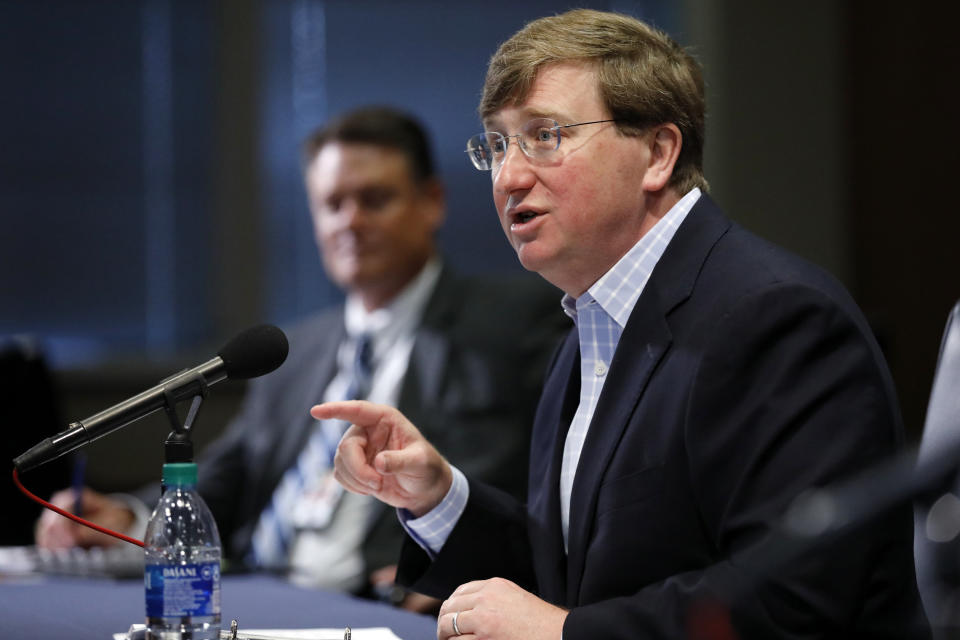 Gov. Tate Reeves, right, answers questions at his coronavirus news briefing while Stephen McRaney, deputy director of the Mississippi Emergency Management Agency, background, listens, in Jackson, Miss., Wednesday, July 8, 2020. (AP Photo/Rogelio V. Solis)