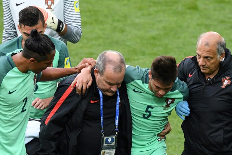 Portugal's defender Raphael Guerreiro (2nd R) is led off the pitch to receive medical attention during the 2017 Confederations Cup group A football match against Russia June 21, 2017