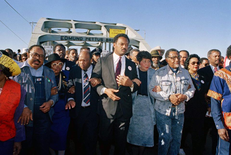 Civil rights figures including Rep. John Lewis, third from left, and Rev. Jesse Jackson, center, lead marchers across the Edmund Pettus Bridge in Selma, Alabama, on March 4, 1990.